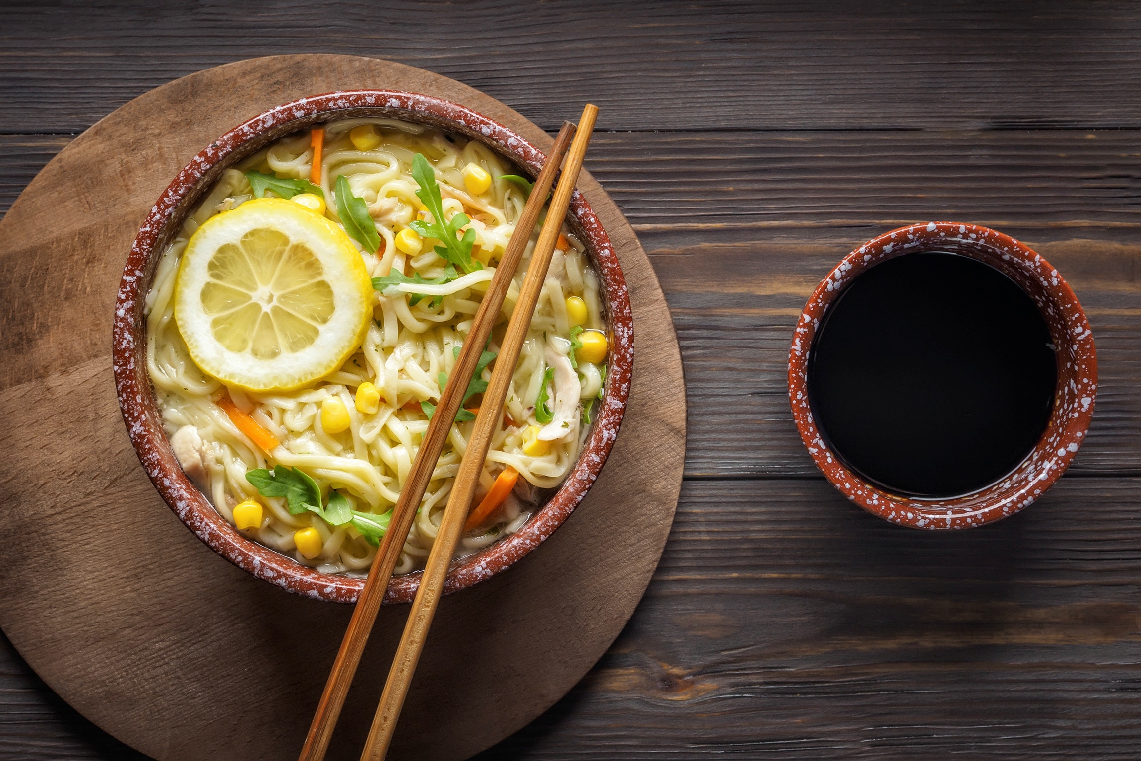 Crab and corn soup with noodles in a bowl, served with chopsticks