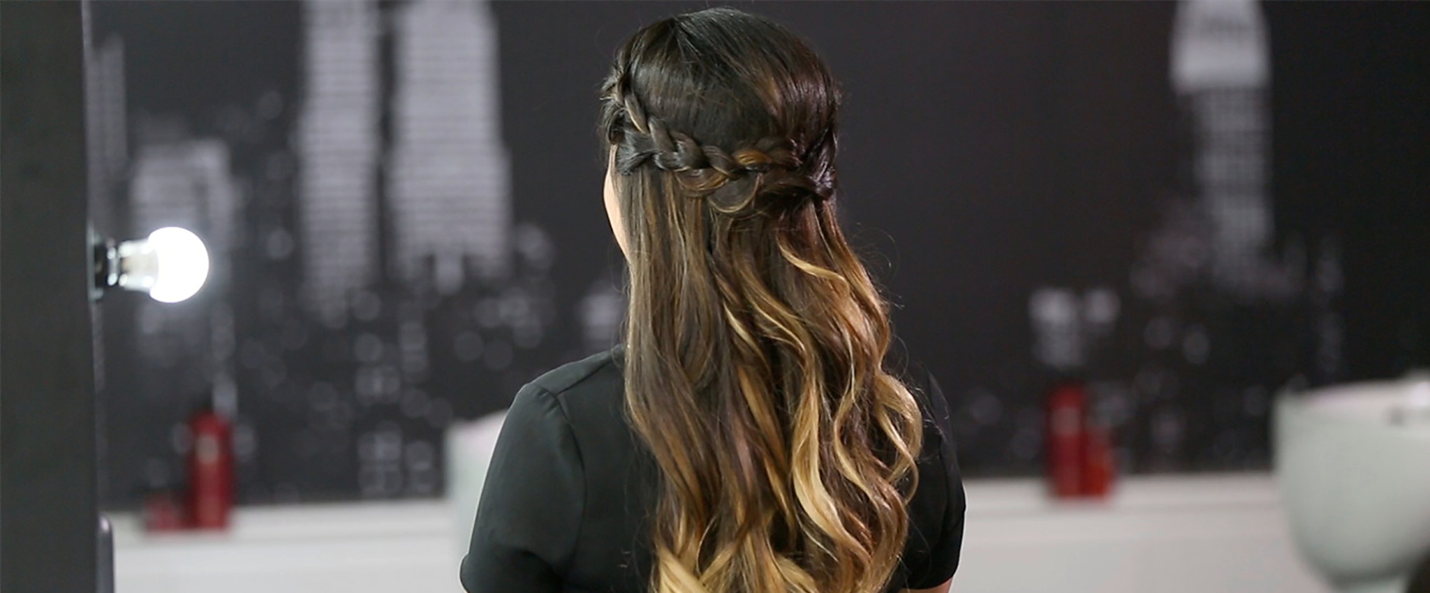 A model with long brown hair styled into a braided crown.