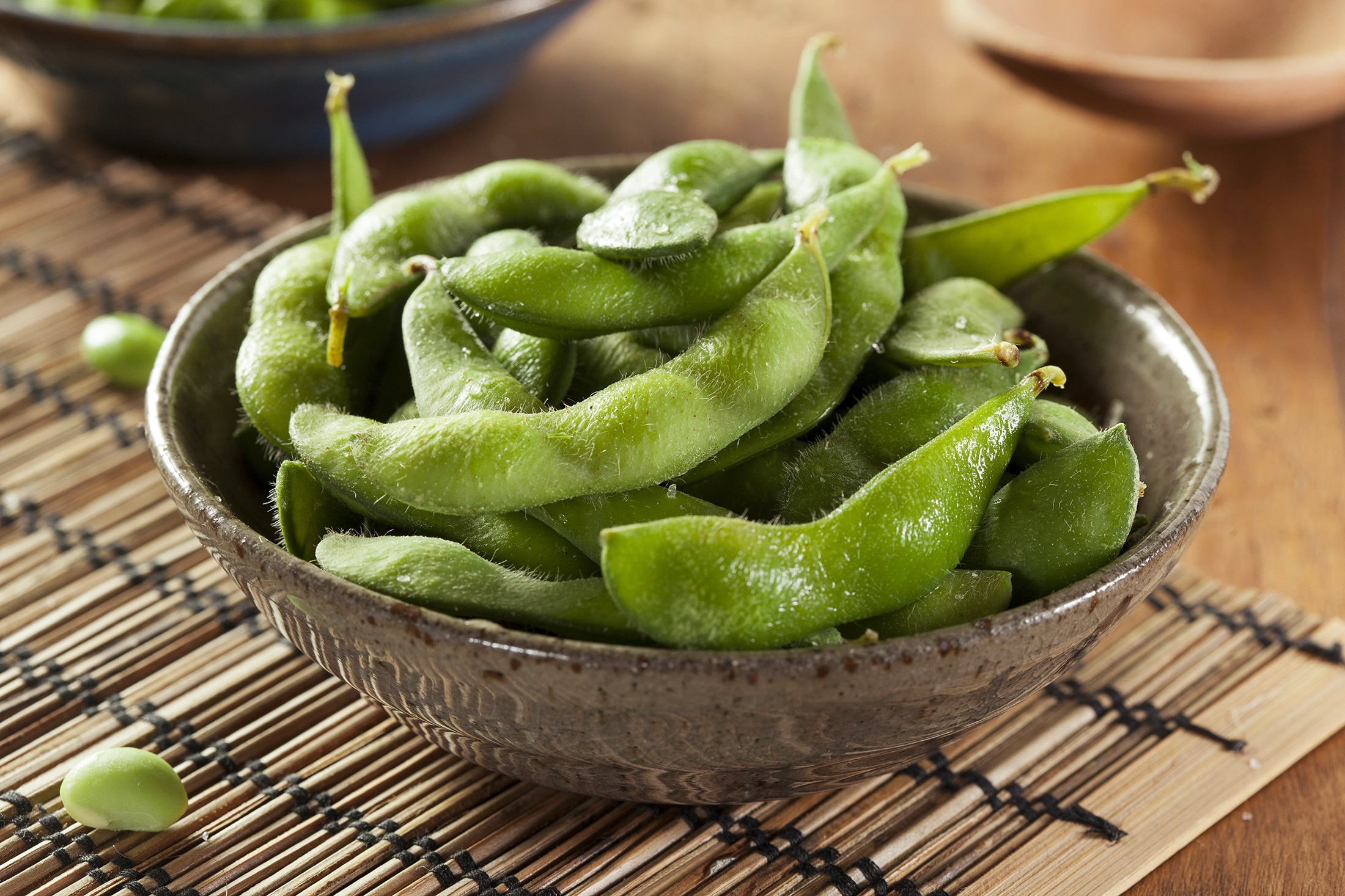 A bowl of edamame on a wooden table