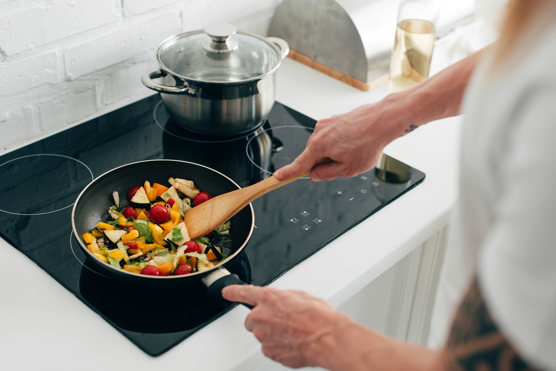 A home cook frying vegetables in a pan