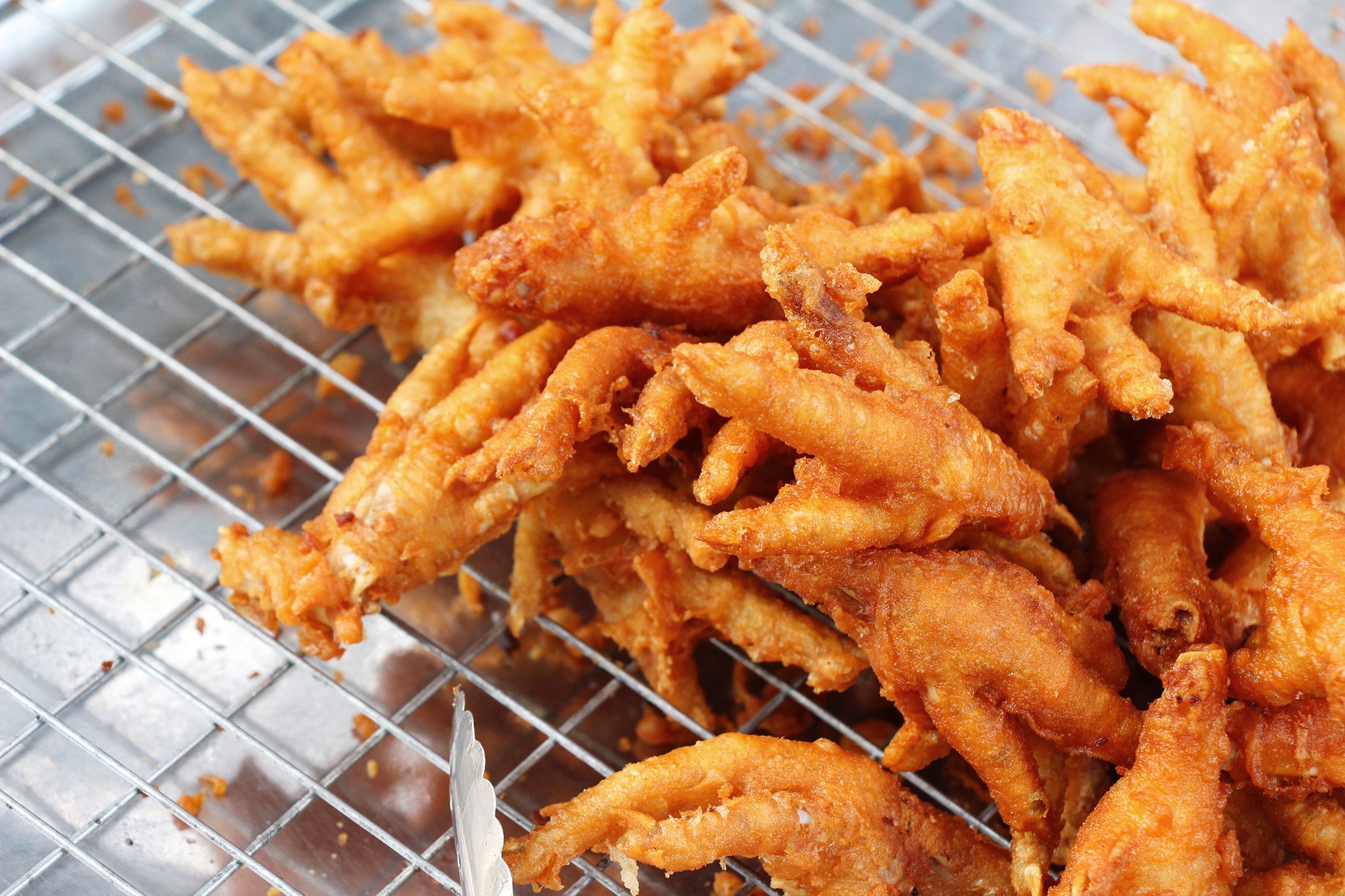 A tray of deep-fried, golden brown chicken feet